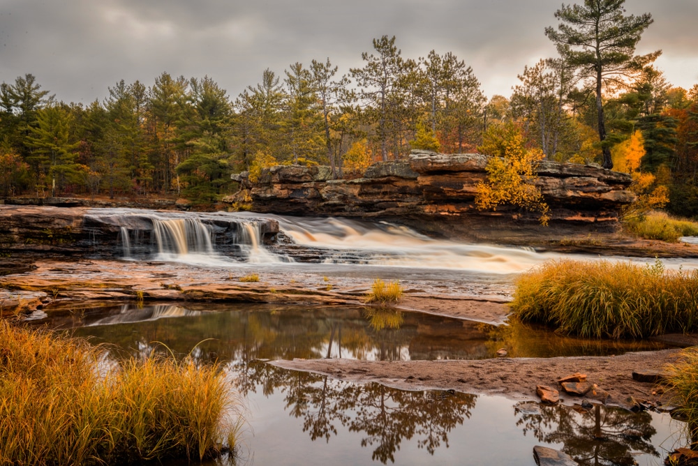 stunning golden hues around a waterfall - the best of Minnesota Fall colors
