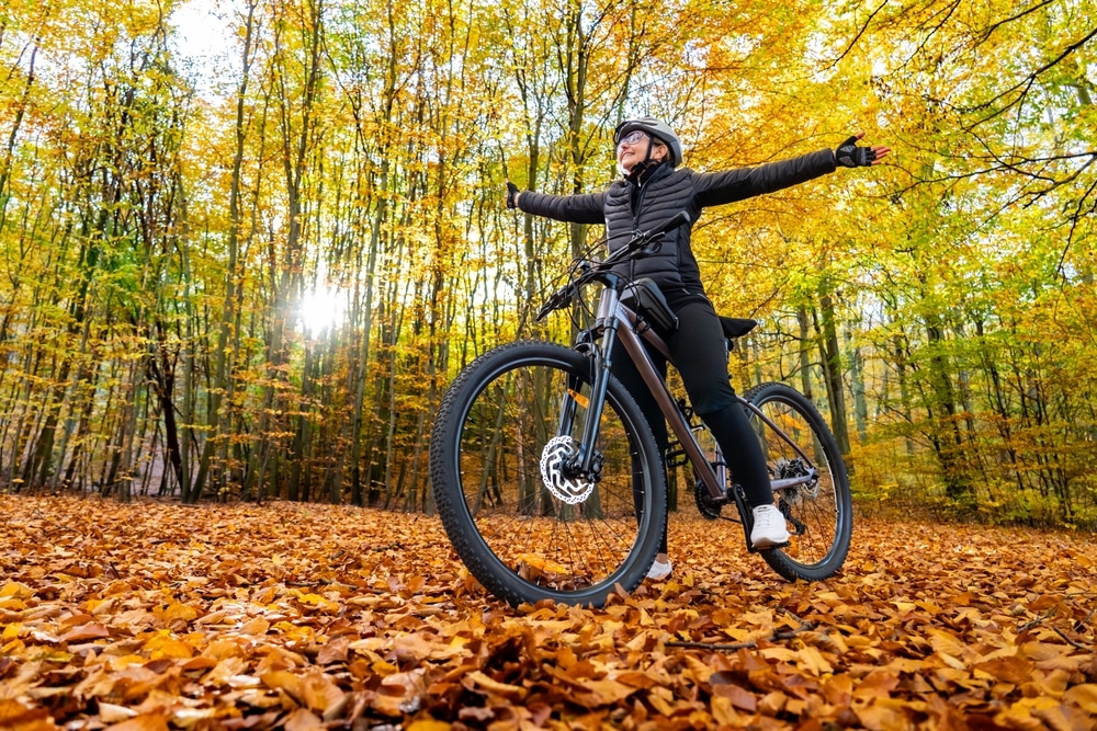 Woman biking through fall colors on the Mississippi River Trail iln the Midwest