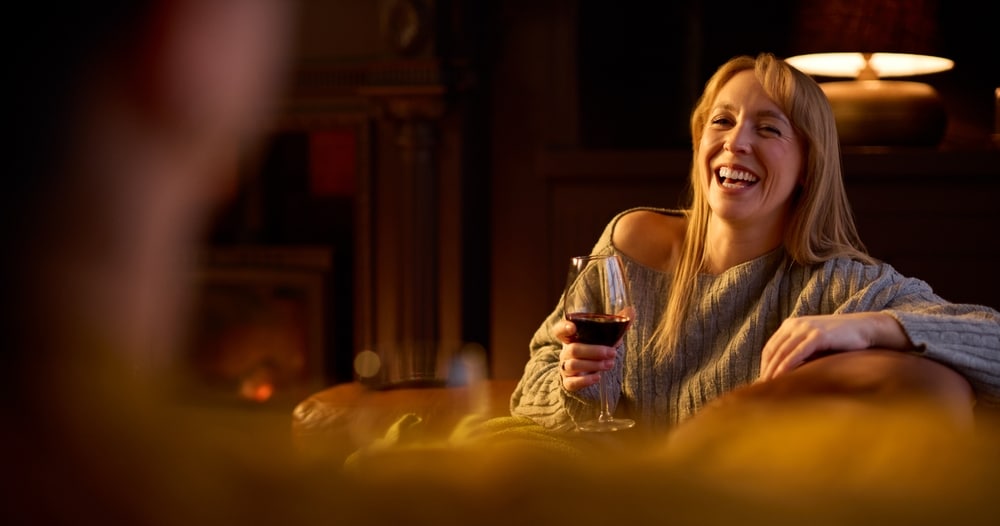 Two women enjoying wine by the fire during romantic getaways in Wisconsin