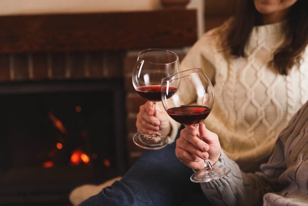 Couple enjoying wine by the fire at the most romantic places to stay in Illinois