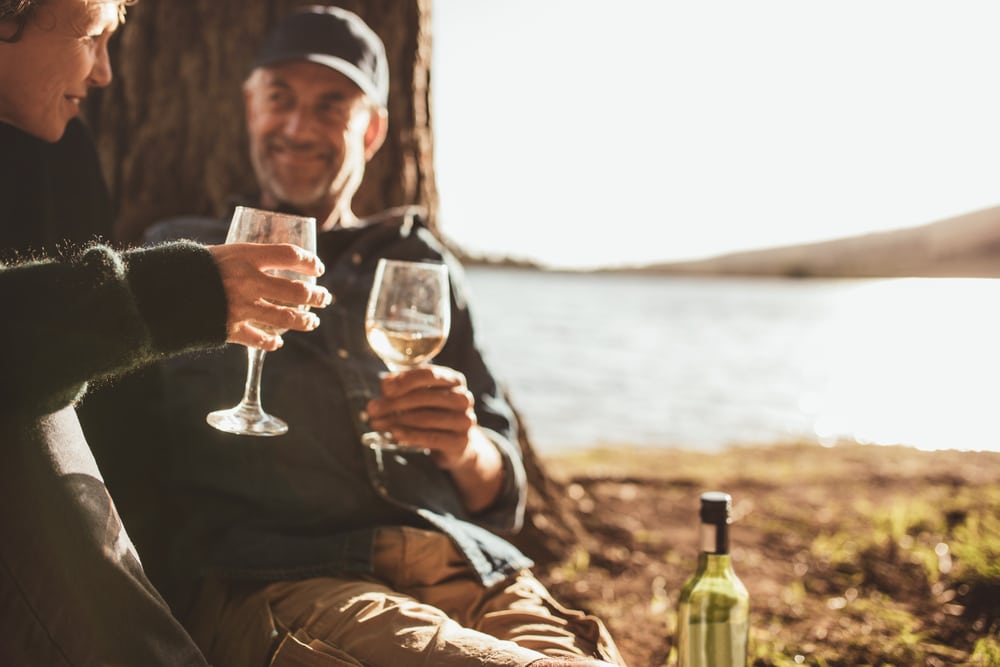 Middle age couple drinking wine by the water during romantic getaways in Minnesota