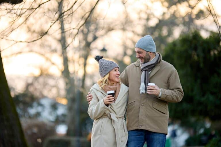 Couple enjoying a walk with a cup of coffee while exploring the most romantic towns in Minnesota