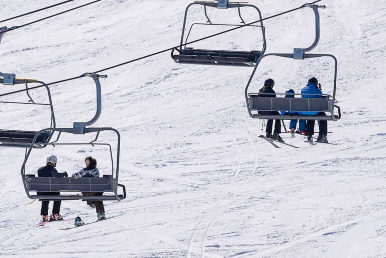 Skiers on a ski lift while enjoying places like Cascade Mountain Wisconsin