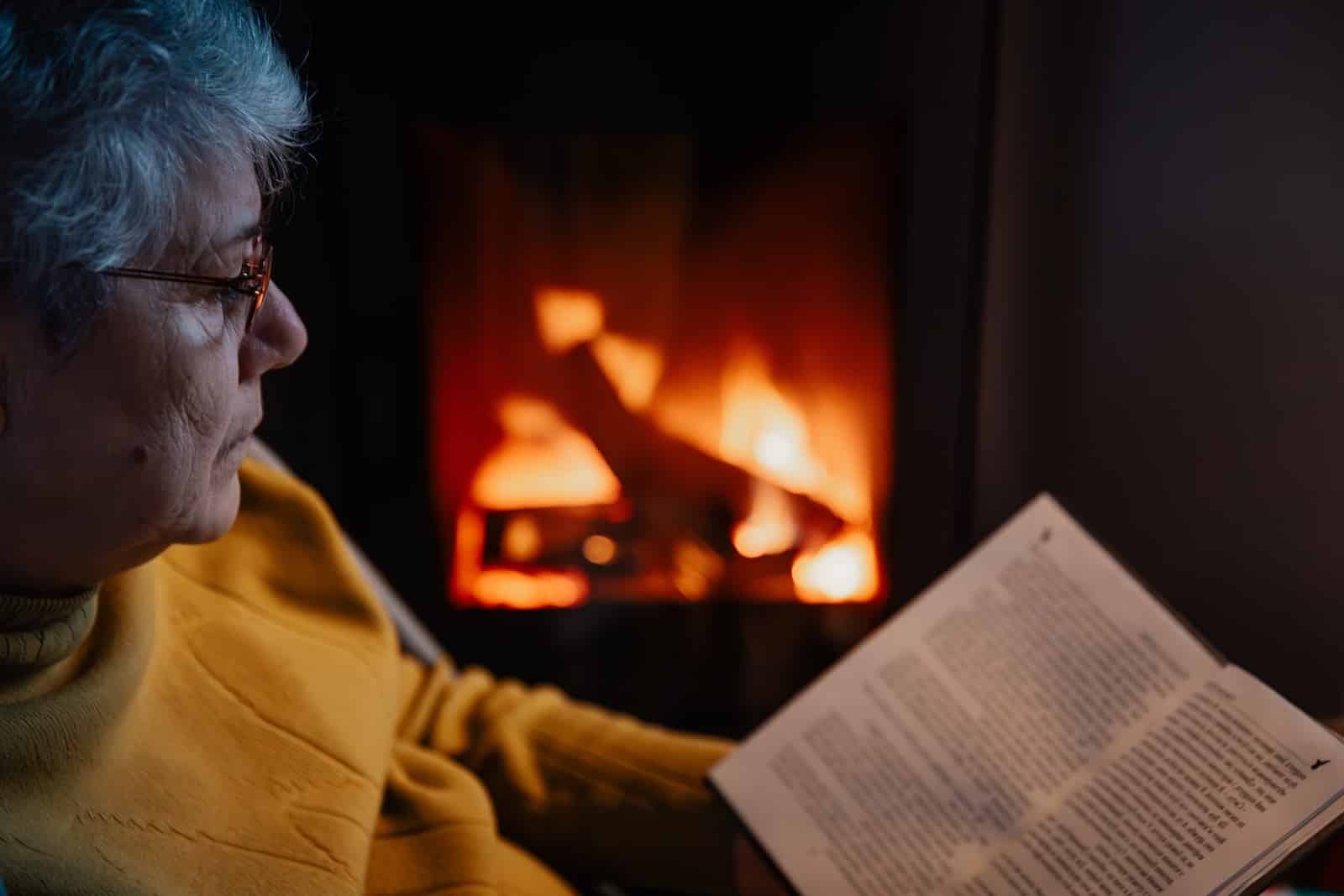 Woman reading by the fire of a day of adventure on Wisconsin snowmobile trails